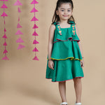 Girl wearing Green Cotton frock which has embroidered straps and layers