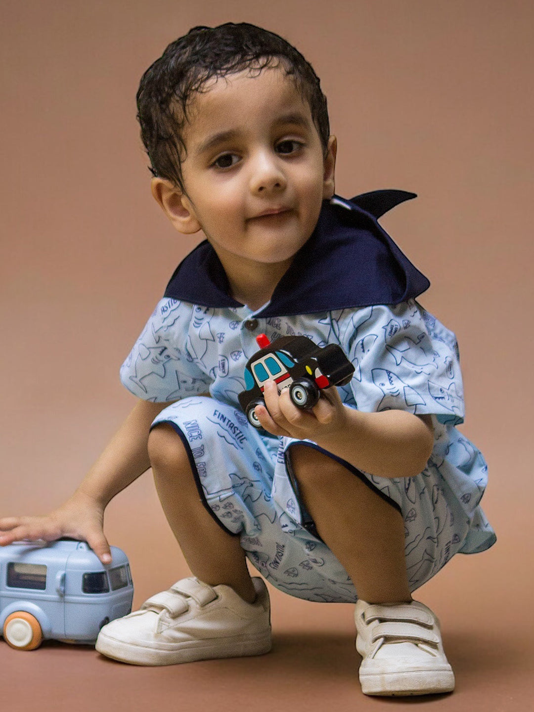 Boy wearing Sharks printed Cotton Coord set which has a hood nd holding a toy in hand