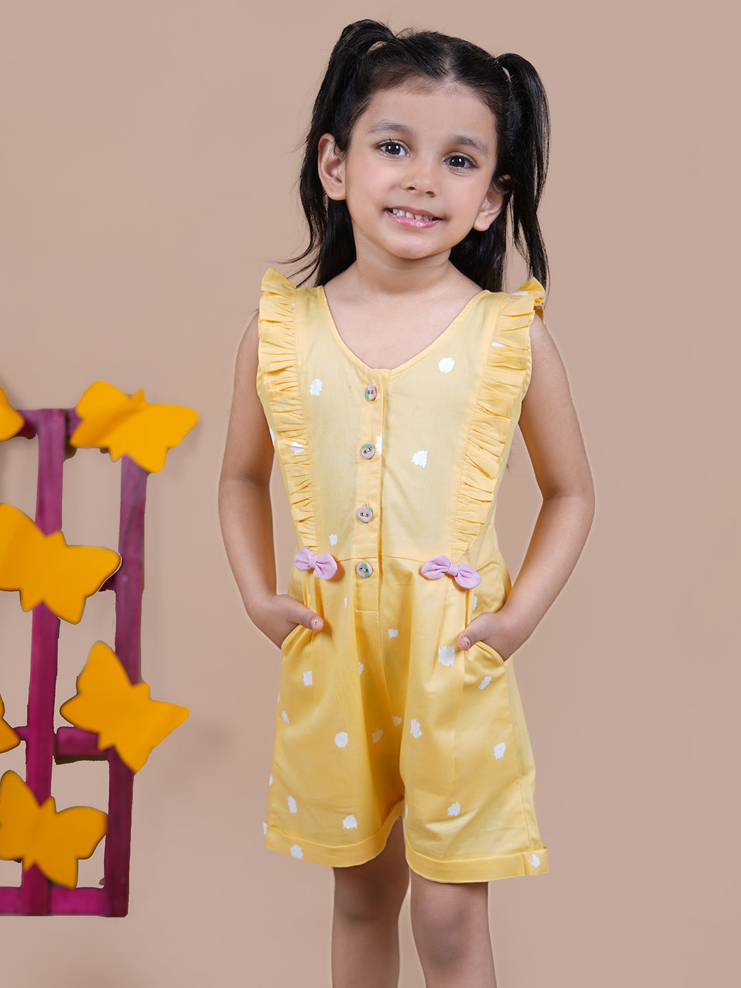 Girl wearing Yellow Jumpsuit with white dots and pink bows