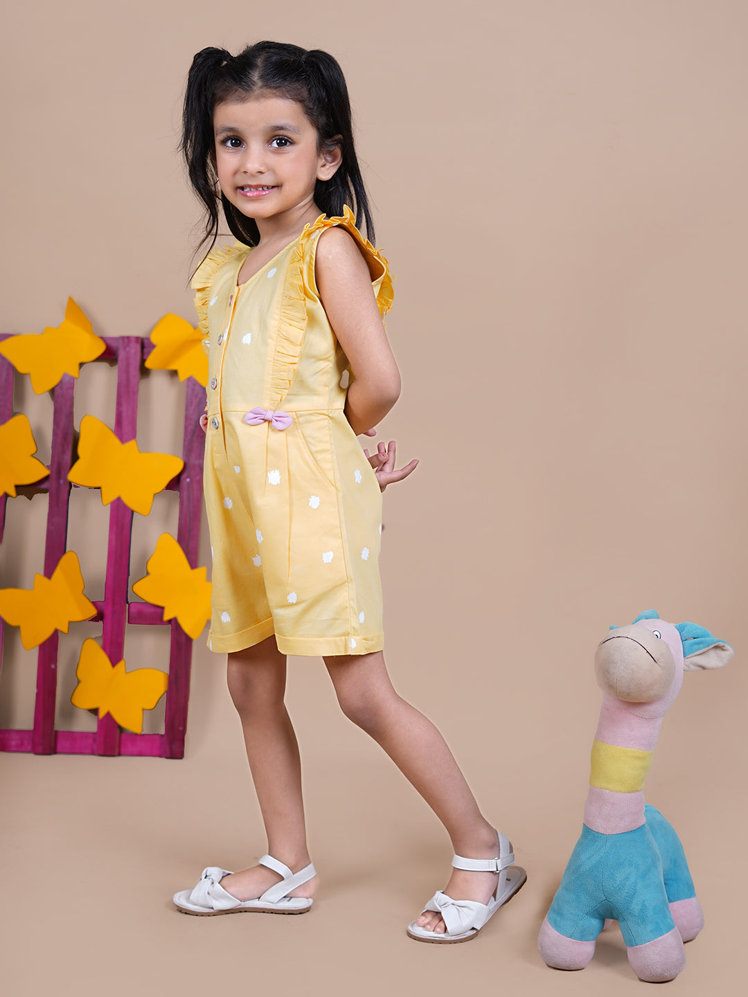 Girl wearing Yellow Jumpsuit with white dots and pink bows