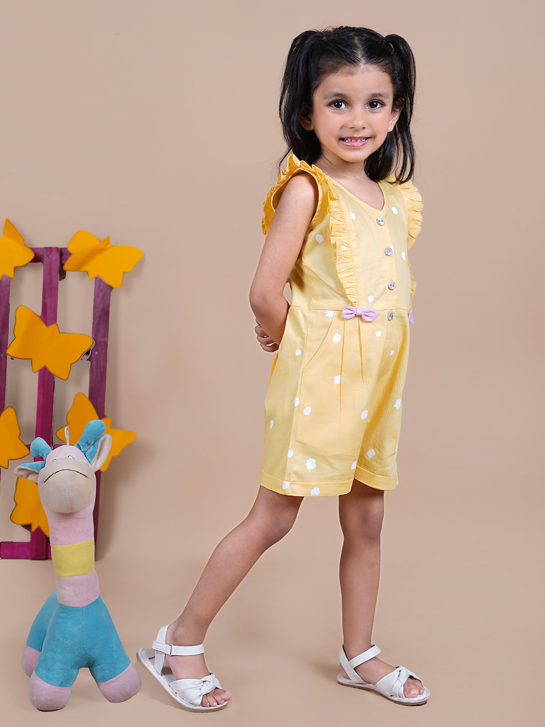 Girl wearing Yellow Jumpsuit with white dots and pink bows