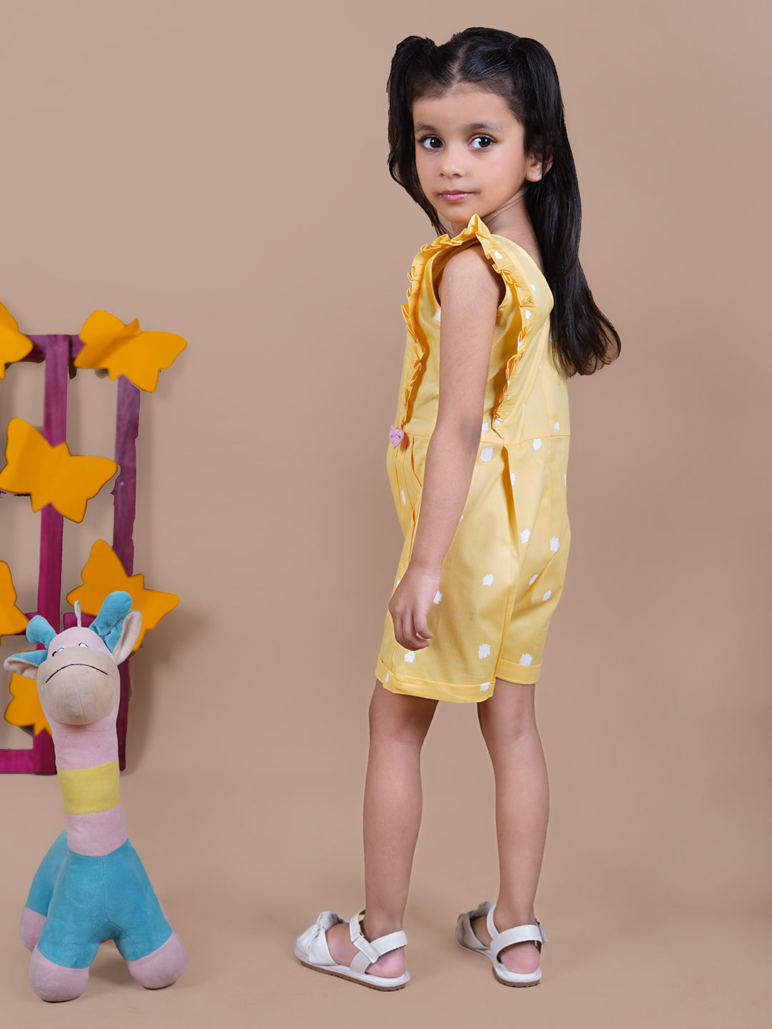 Girl wearing Yellow Jumpsuit with white dots and pink bows