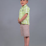 A boy wearing lime green drop shoulders shirt and beige linen shorts