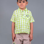 A boy wearing lime green drop shoulders shirt and beige linen shorts