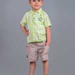 A boy wearing lime green drop shoulders shirt and beige linen shorts