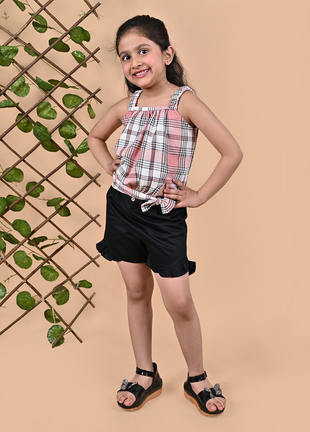 A girl wearing Checks top with straps and black shorts