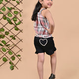 A girl wearing Checks top with straps and black shorts