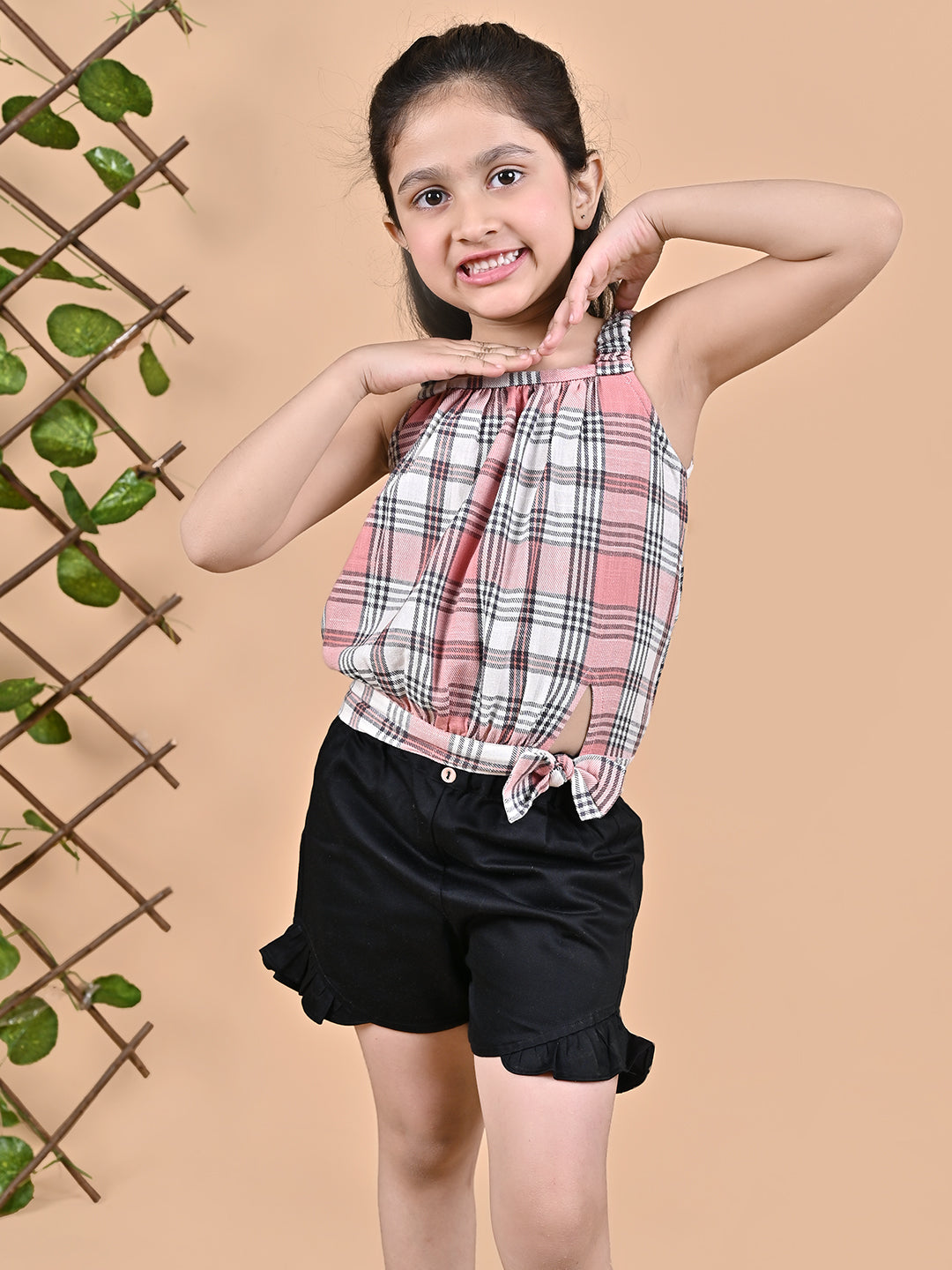 A girl wearing Checks top with straps and black shorts