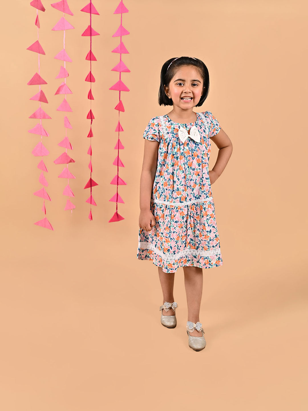 Girl wearing FLoral printed cotton frock that has a bow