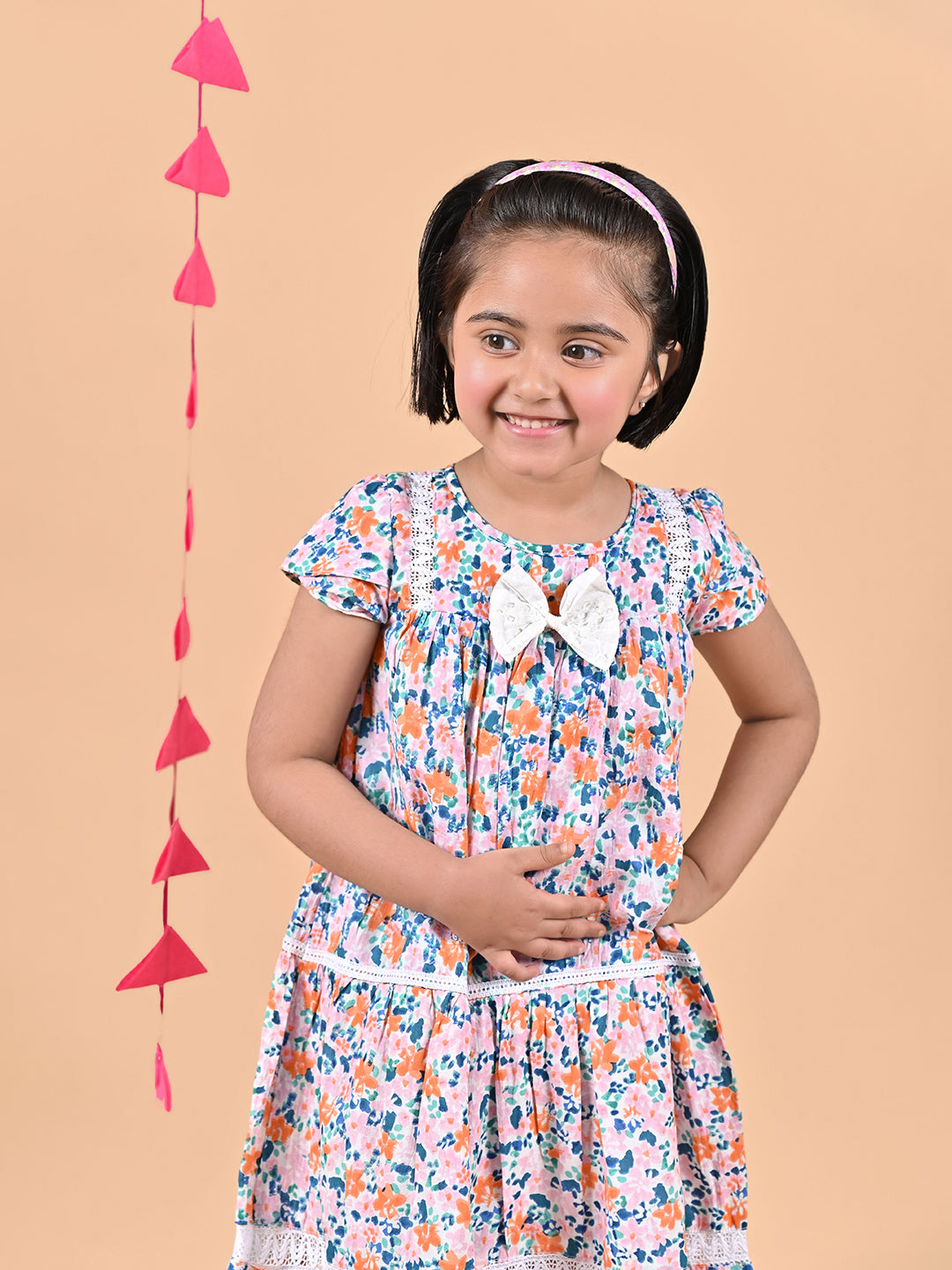 Girl wearing FLoral printed cotton frock that has a bow