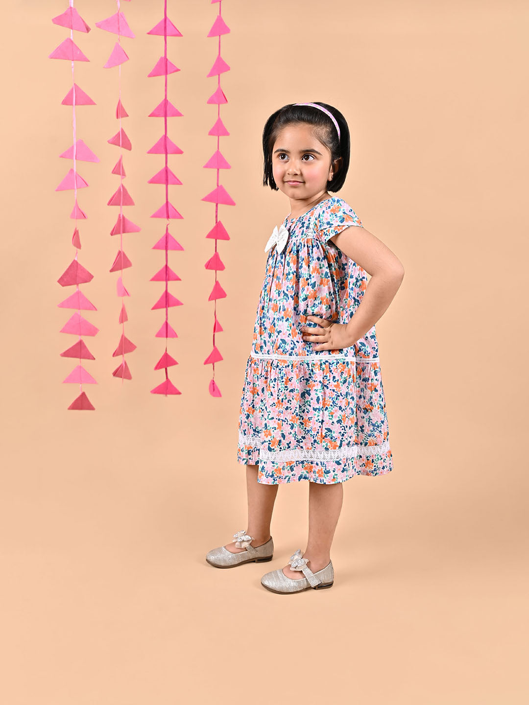 Girl wearing FLoral printed cotton frock that has a bow