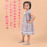 Girl wearing FLoral printed cotton frock that has a bow