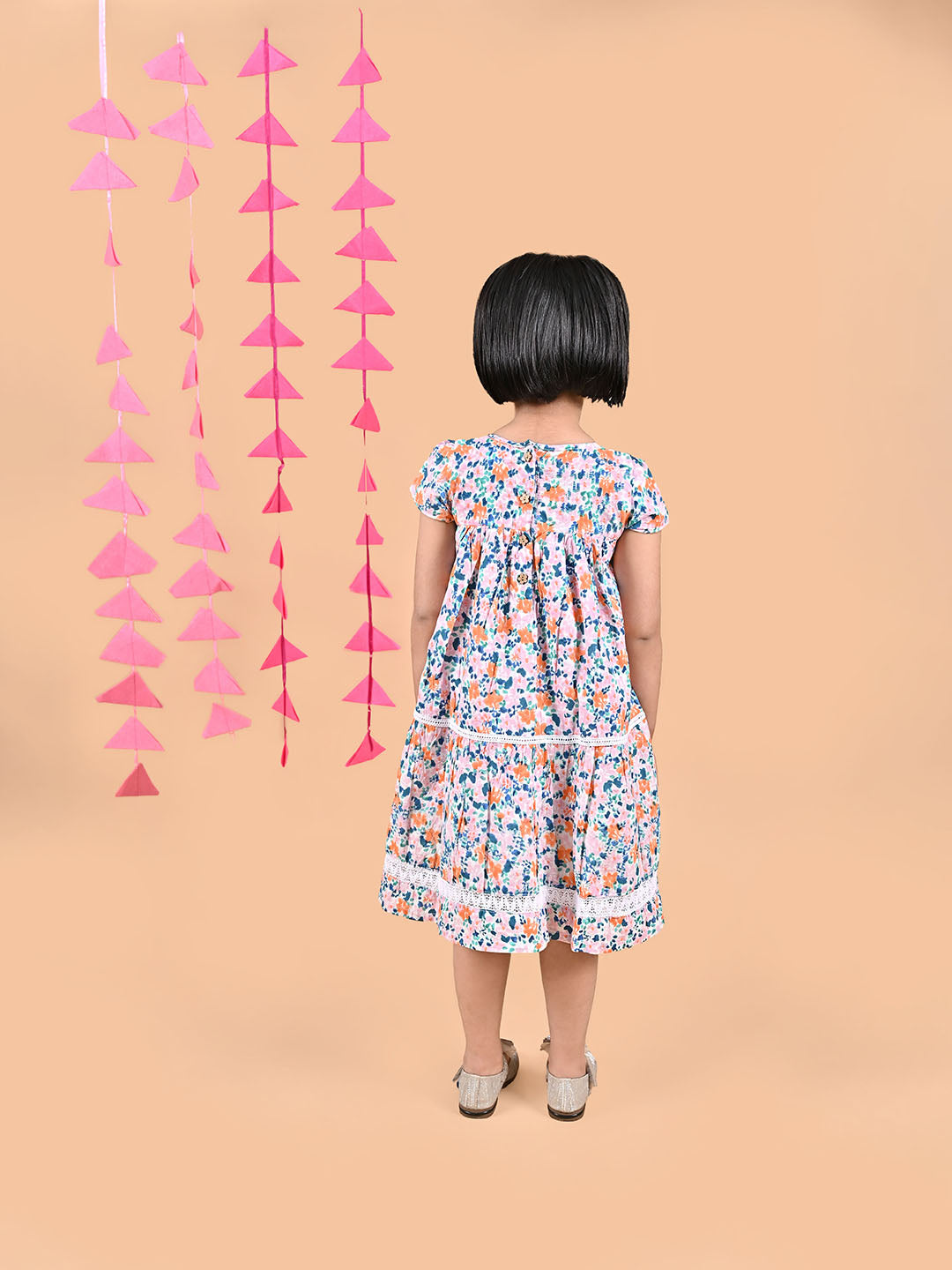 Girl wearing FLoral printed cotton frock that has a bow