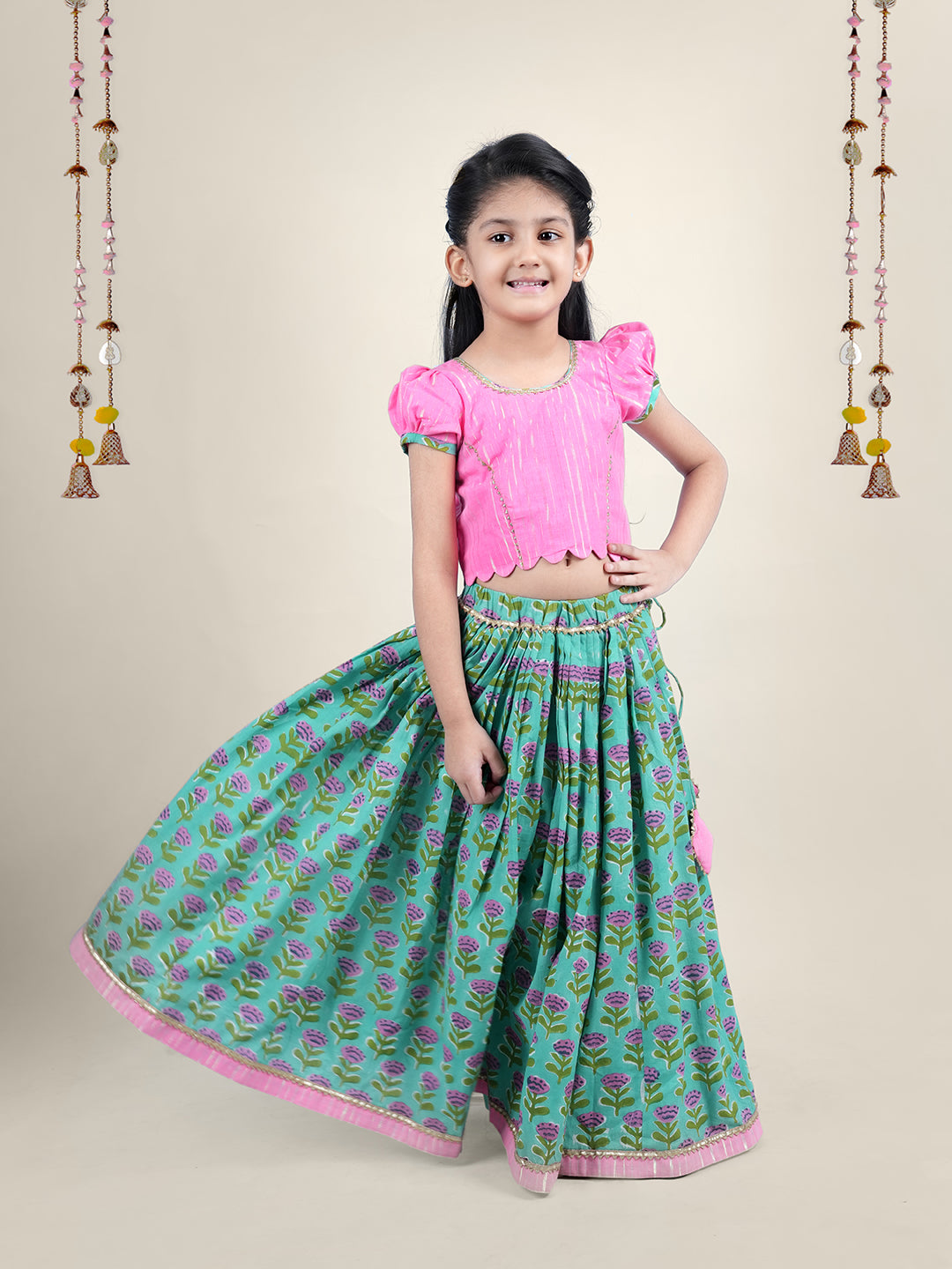 A girl wearing traditional attire in candy pink Cotton top and Green Block print skirt