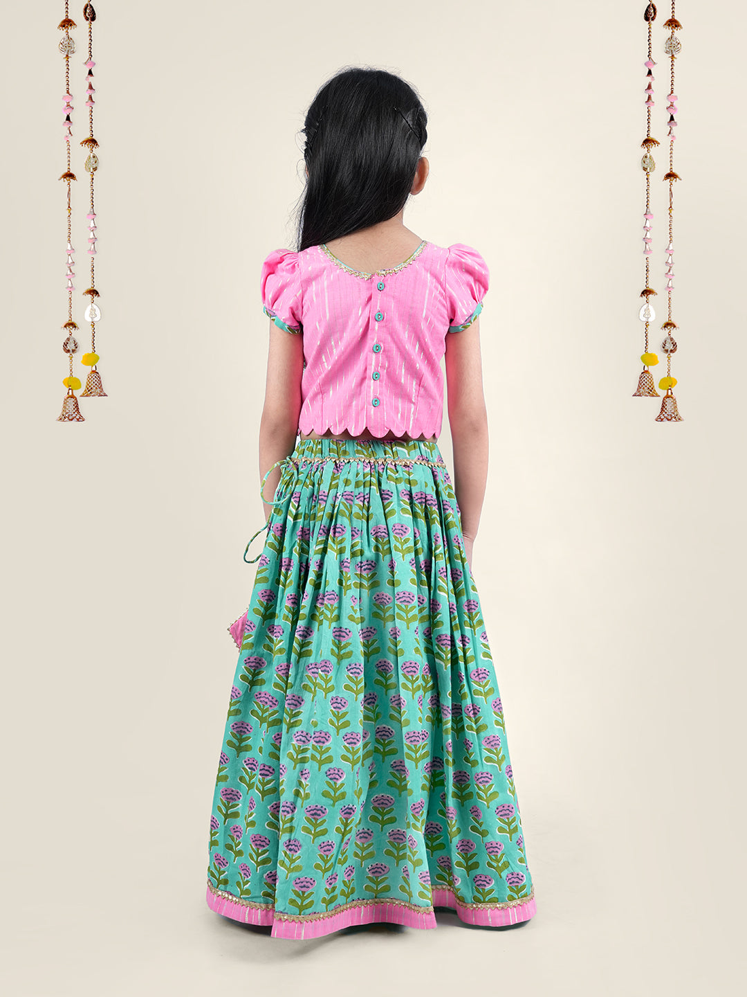 A girl wearing traditional attire in candy pink Cotton top and Green Block print skirt