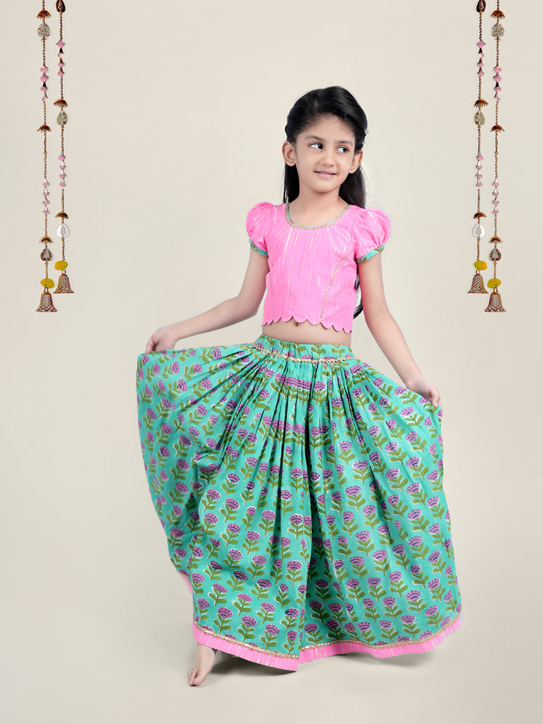 A girl wearing traditional attire in candy pink Cotton top and Green Block print skirt