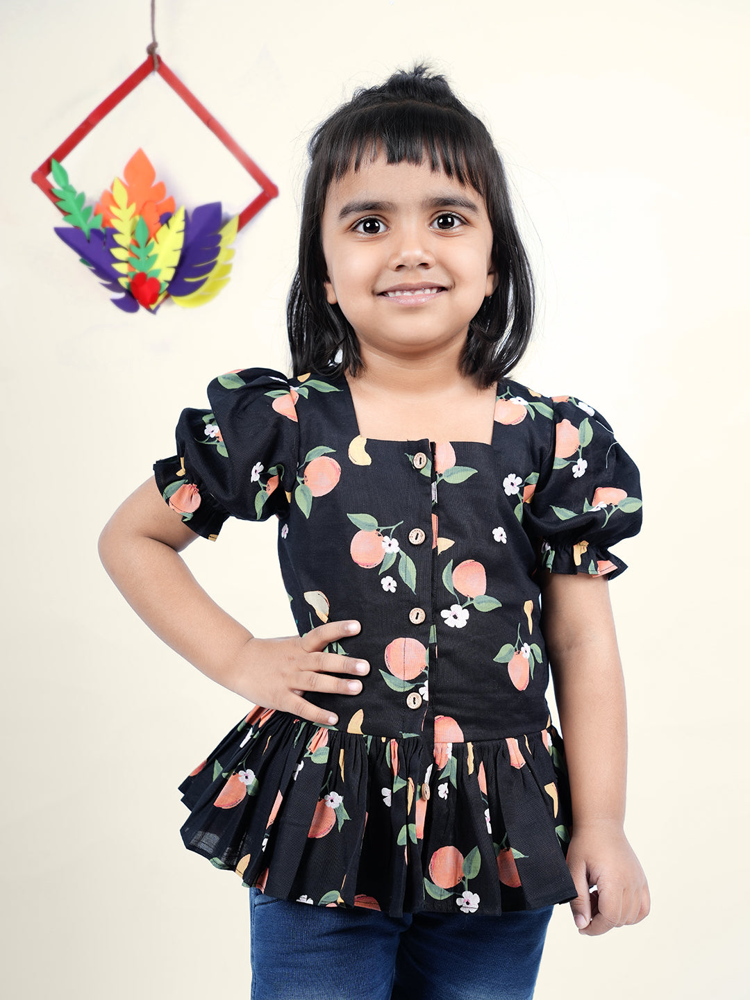 A Girl wearing Black Cotton Top with Peaches printed on it