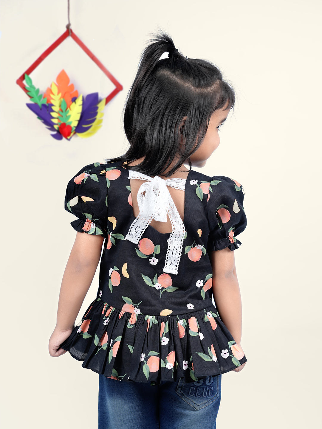 A Girl wearing Black Cotton Top with Peaches printed on it