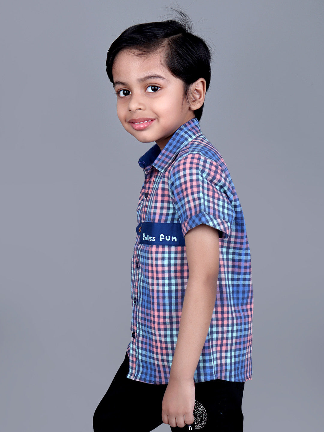 Boy wearing Blue Checks shirt with endless fun written on it