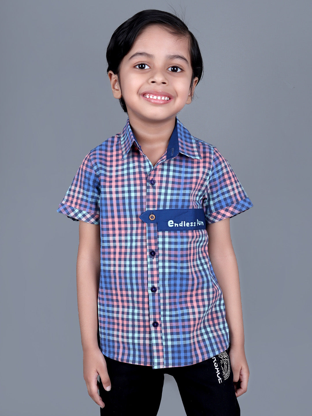 Boy wearing Blue Checks shirt with endless fun written on it