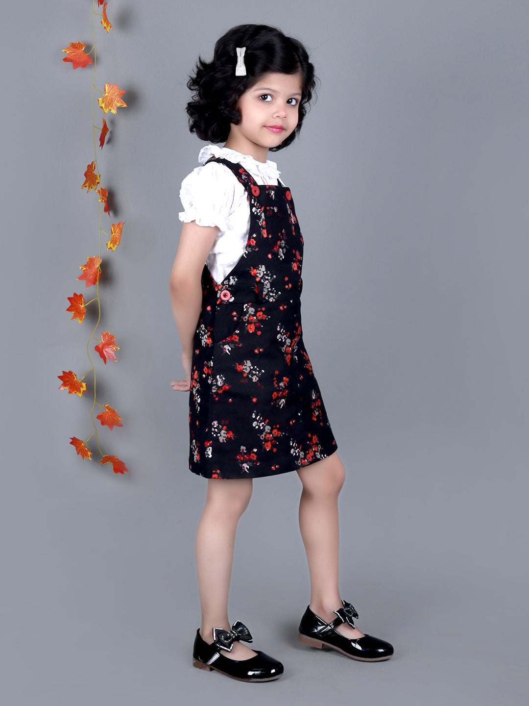 Smiling girl wearing Black floral Cotton Dungree with White Top inside