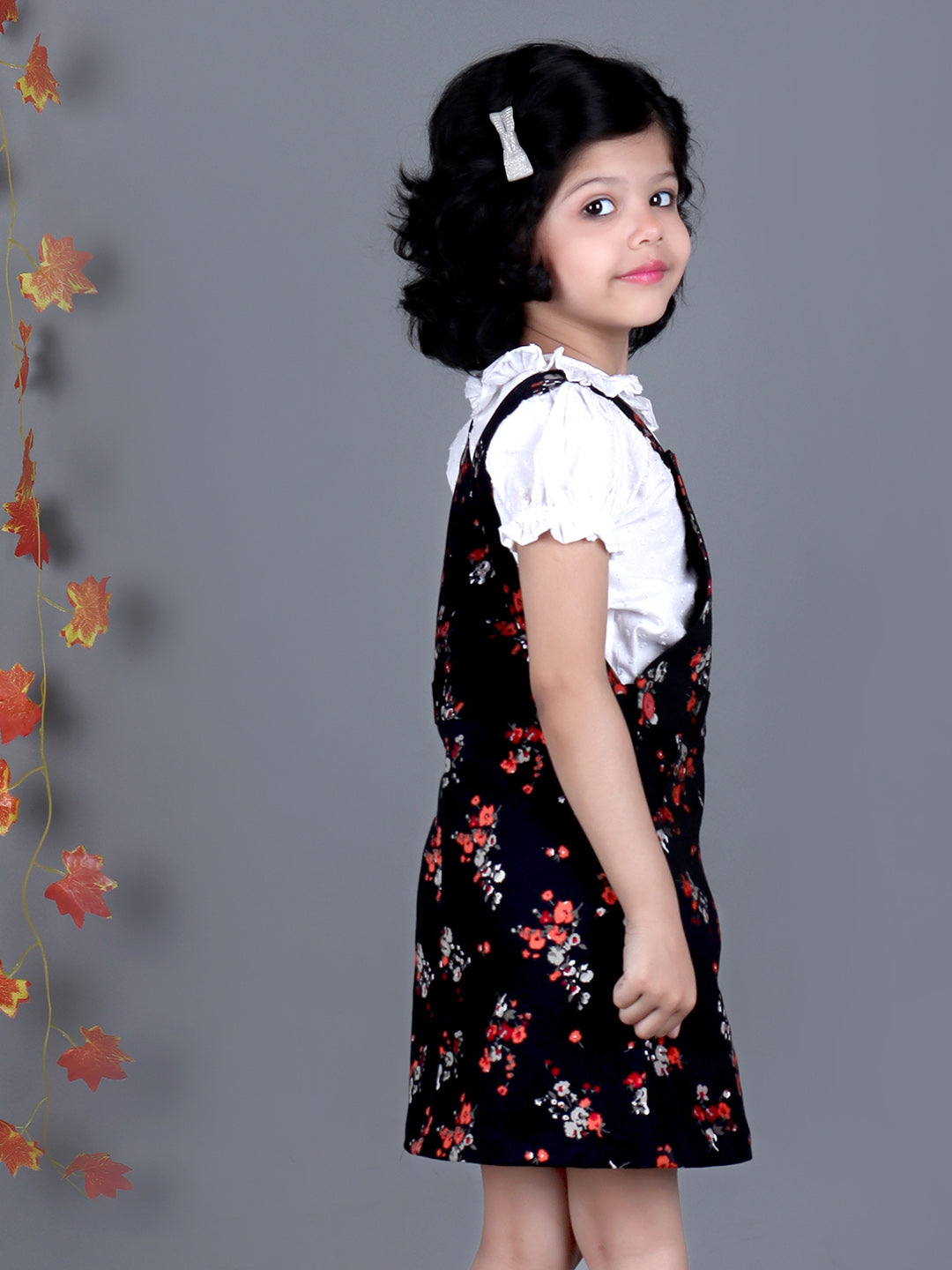 Smiling girl wearing Black floral Cotton Dungree with White Top inside