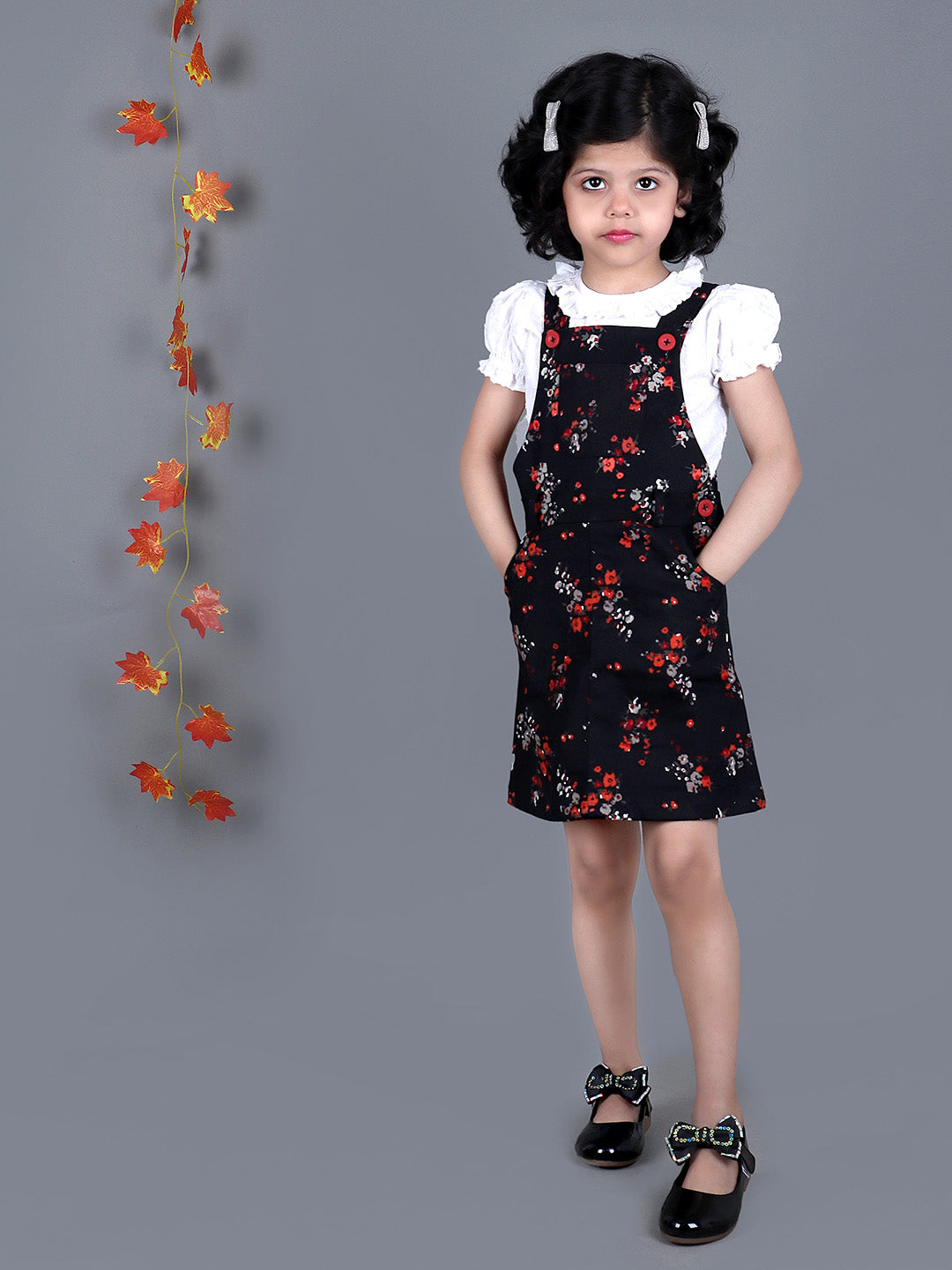 Girl wearing Black floral Cotton Dungree with White Top inside