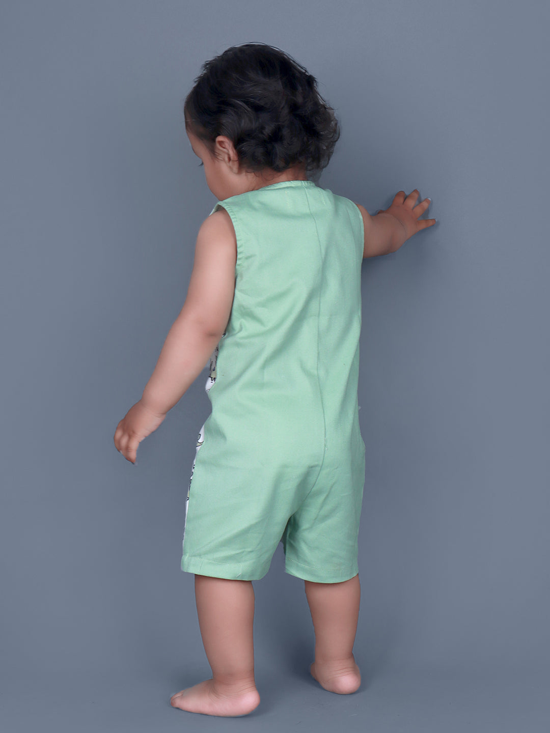 Baby boy wearing Dino printed green romper with a cute tail popping out