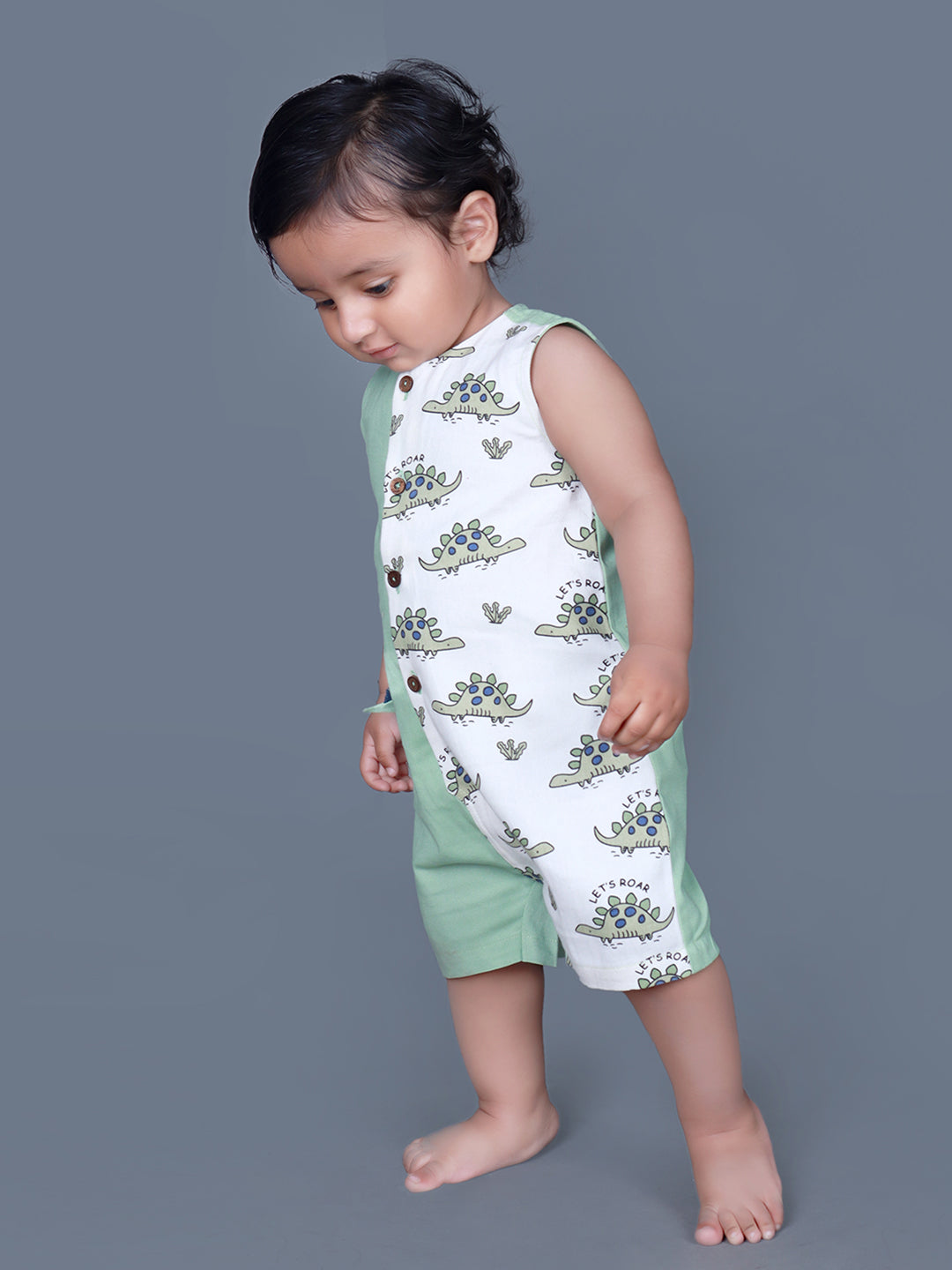 Baby boy wearing Dino printed green romper with a cute tail popping out