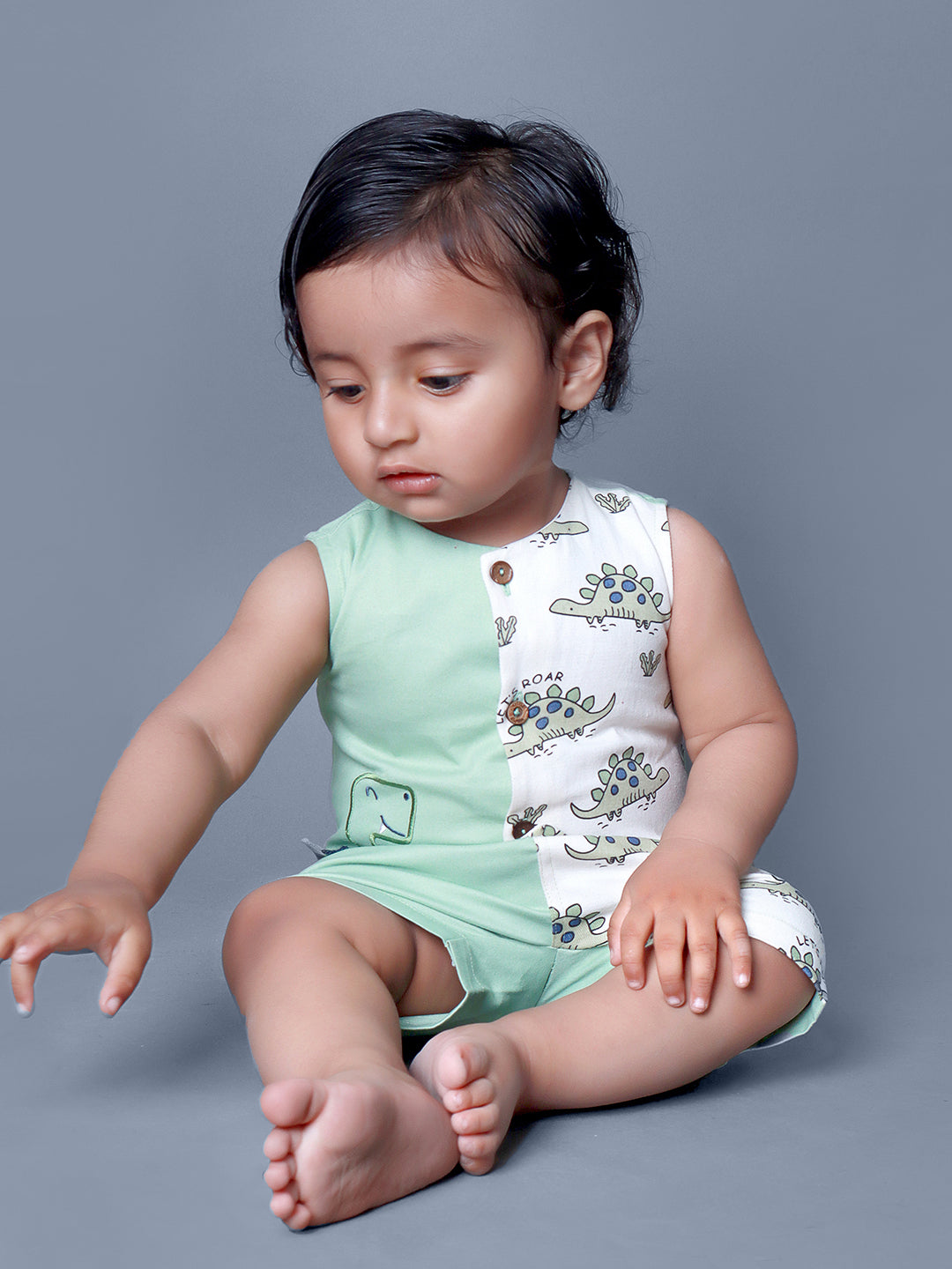 Baby boy wearing Dino printed green romper with a cute tail popping out