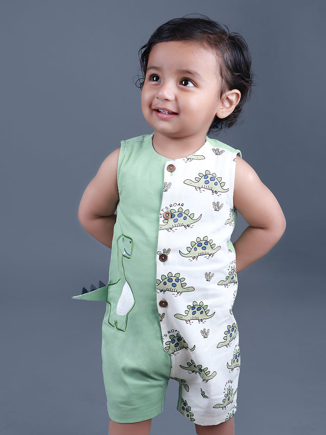 Baby boy wearing Dino printed green romper with a cute tail popping out