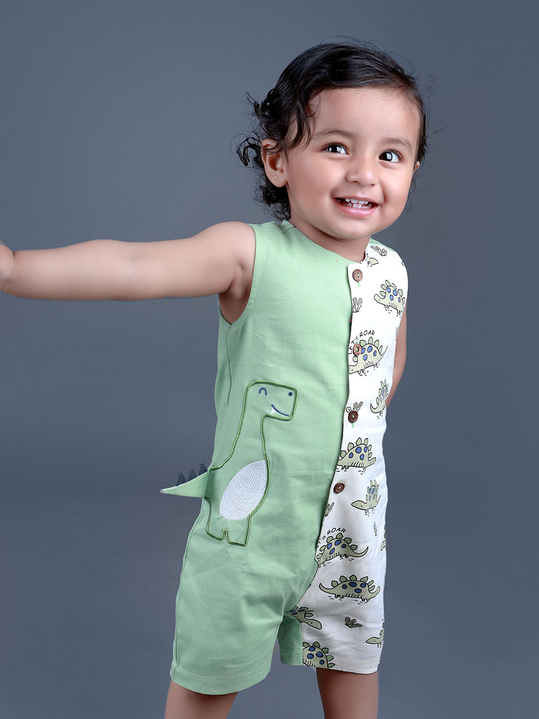 Baby boy wearing Dino printed green romper with a cute tail popping out