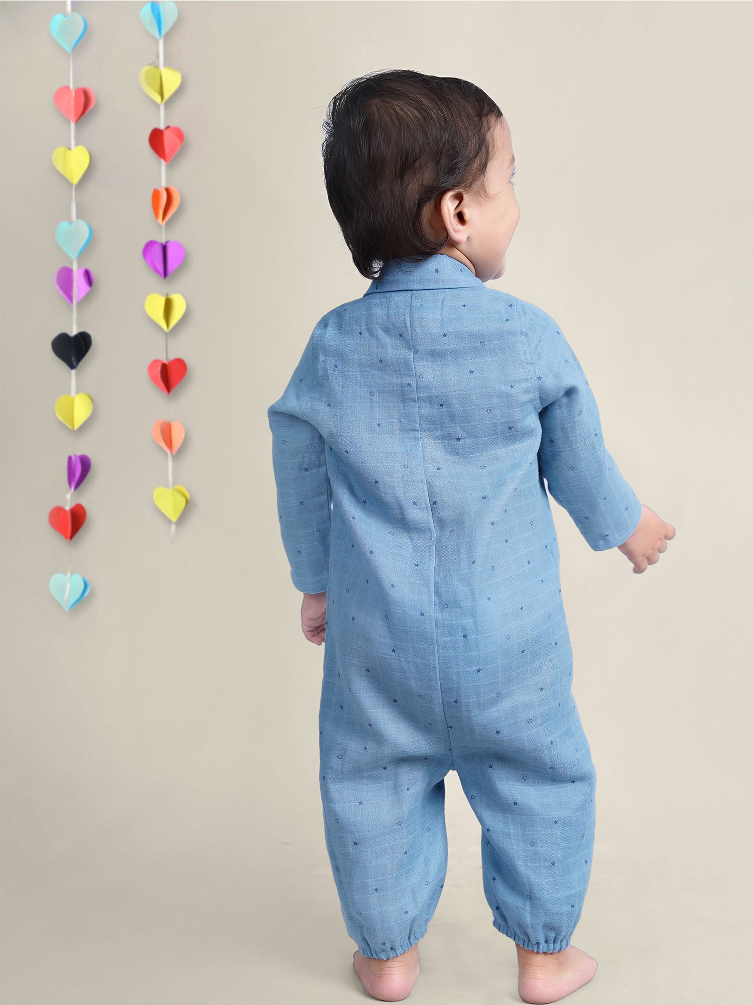 Smiling Baby Boy wearing blue cotton romper with stars on it