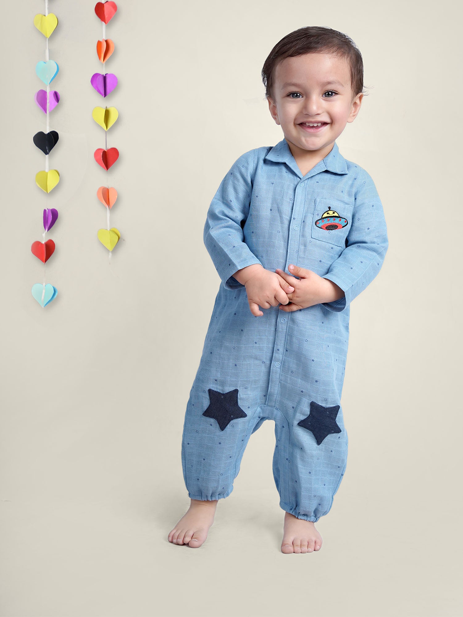 Smiling Baby Boy wearing blue cotton romper with stars on it