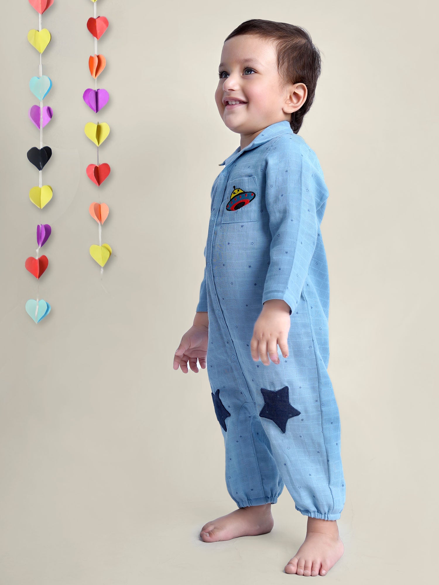 Smiling Baby Boy wearing blue cotton romper with stars on it