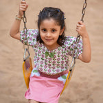 A girl wearing Block print cotton crop top and peach skirt with flowers